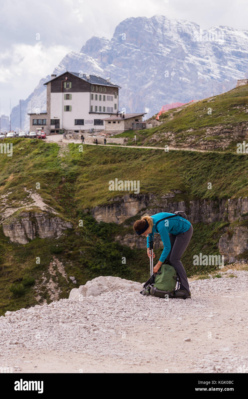 Giovane donna che si prepara per escursioni nelle Dolomiti, Italia. Foto Stock