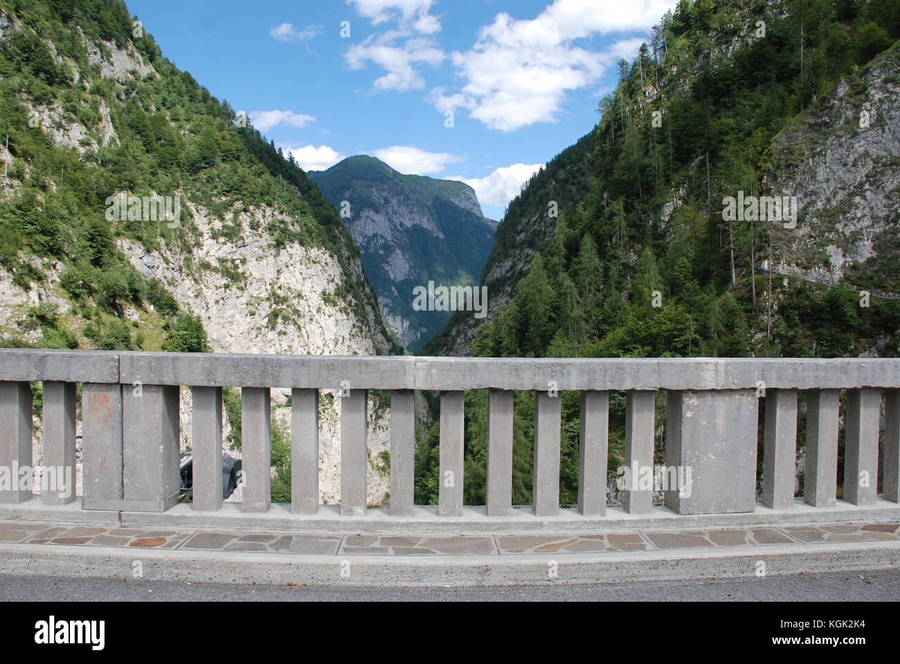 Montagne delle Dolomiti friulane nel nord est Italia. una strada barriera di cemento può essere visto in primo piano. Foto Stock