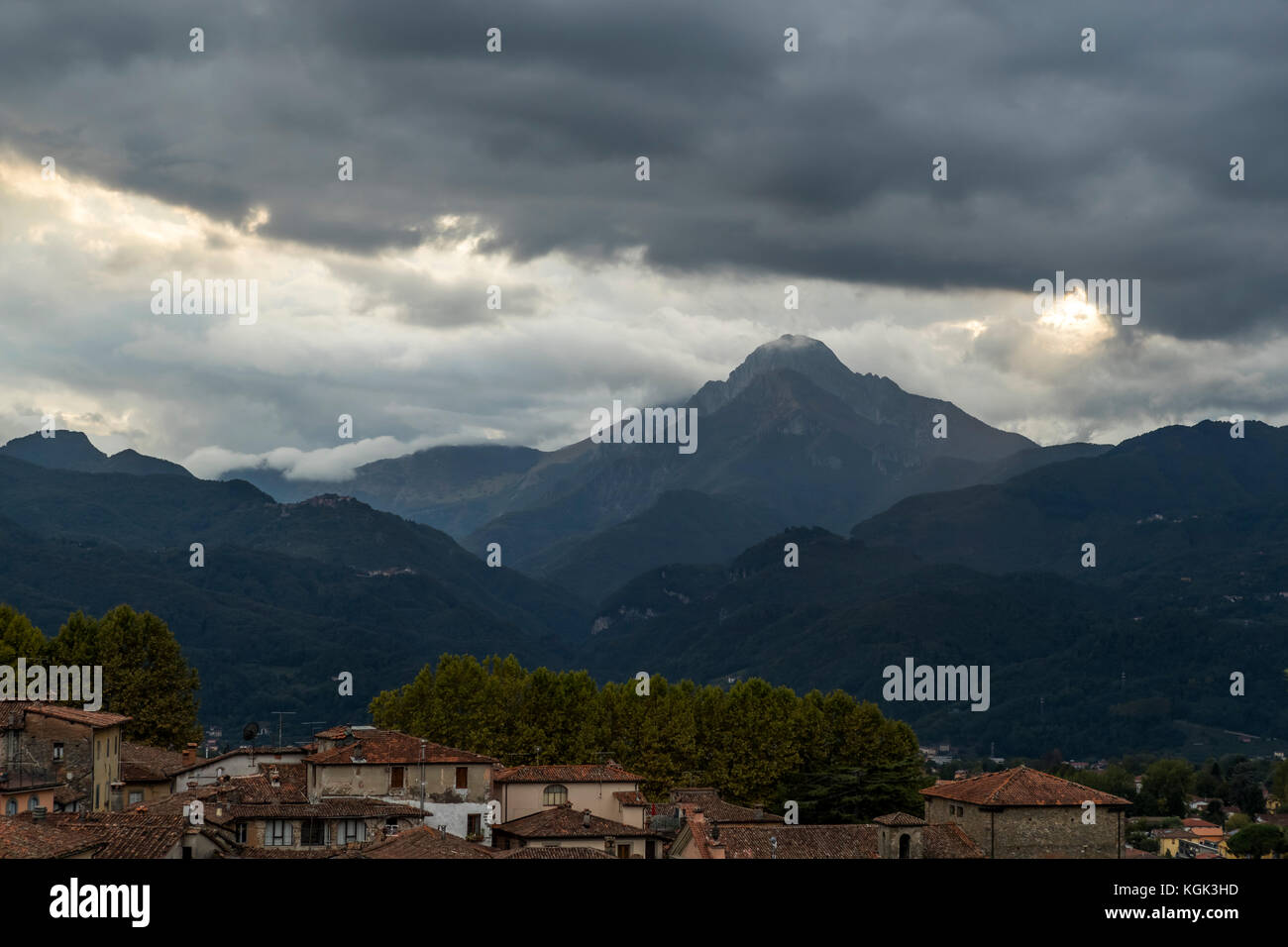 Drammatico il cielo al tramonto con la Pania della Croce al vertice della montagna nelle Alpi Apuane, Italia. Visto dal duomo di Barga. Foto Stock