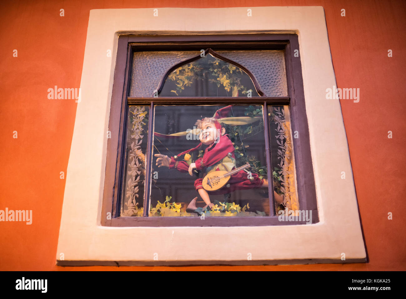 Dettaglio della parete arancione e finestra con un fantoccio, giocattolo di souvenir shop al golden lane in ceco zlata ulicka è una strada situata presso il castello di Praga, Foto Stock