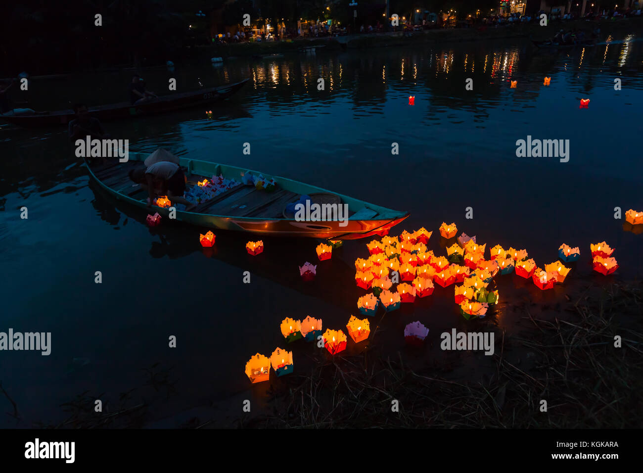 Una famiglia lancio di candele galleggianti sul fiume Thu Bon in antica città di Hoi An, Vietnam. Una vecchia tradizione. Foto Stock