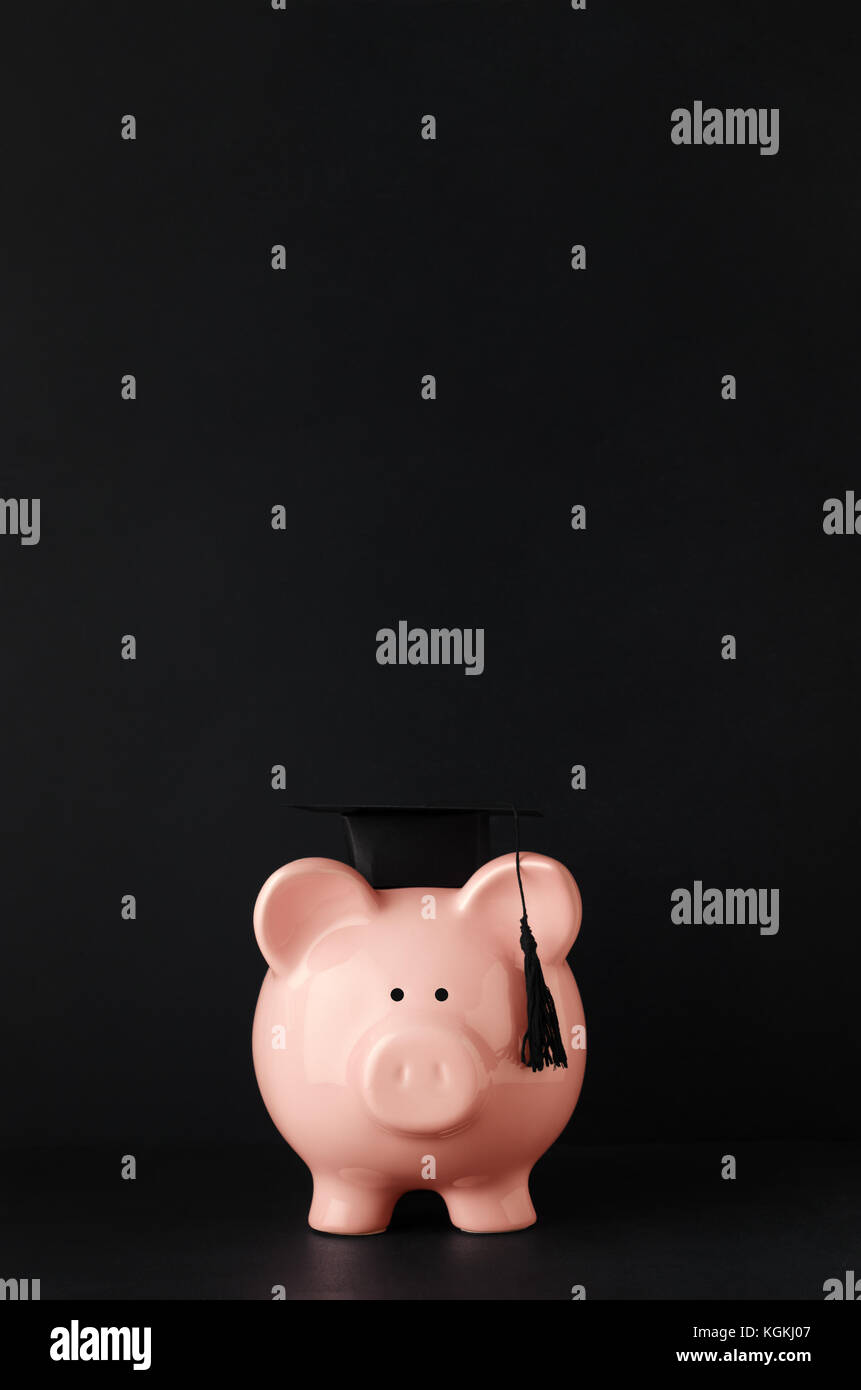 Tasse di iscrizione e contributi concetto con rosa in ceramica salvadanaio rivolto verso la parte anteriore a livello degli occhi indossando un nero mortarboard. Blackboard sfondo con copia spazio sopra. Foto Stock