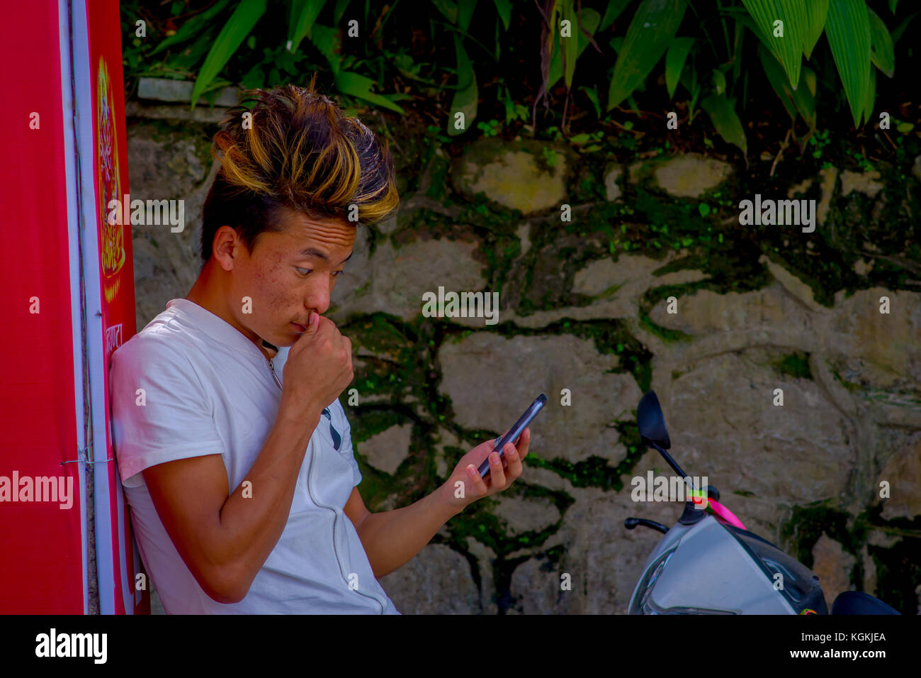 Kathmandu, Nepal - 04 settembre 2017: l'uomo non identificato indossare una t-shirt bianco e prendendo un selfie con il suo cellulare e che posano per una foto in esterno in Kathmandu, Nepal Foto Stock