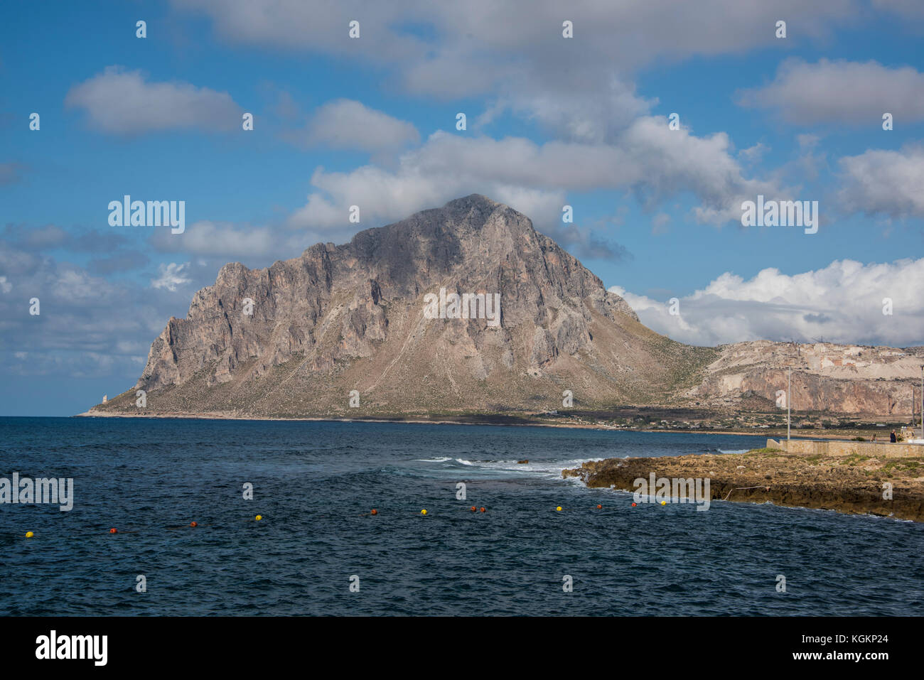 Custonaci cava di marmo e il monte Cofano (cappa montagna) con una piccola baia del Mar Tirreno in primo piano, Sicilia Foto Stock