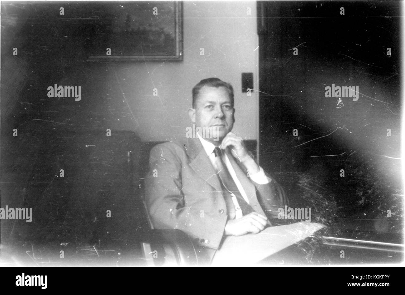 Ritratto di Henry George Homer Halvorson, direttore della Biblioteca presso la Johns Hopkins University nel 1947, seduto nel suo ufficio indossando un vestito, viso pieno, vita in su, mano poggiante sul mento, con un grande pezzo di carta in grembo, circa 50 anni, Baltimora, Maryland, 1948. () Foto Stock