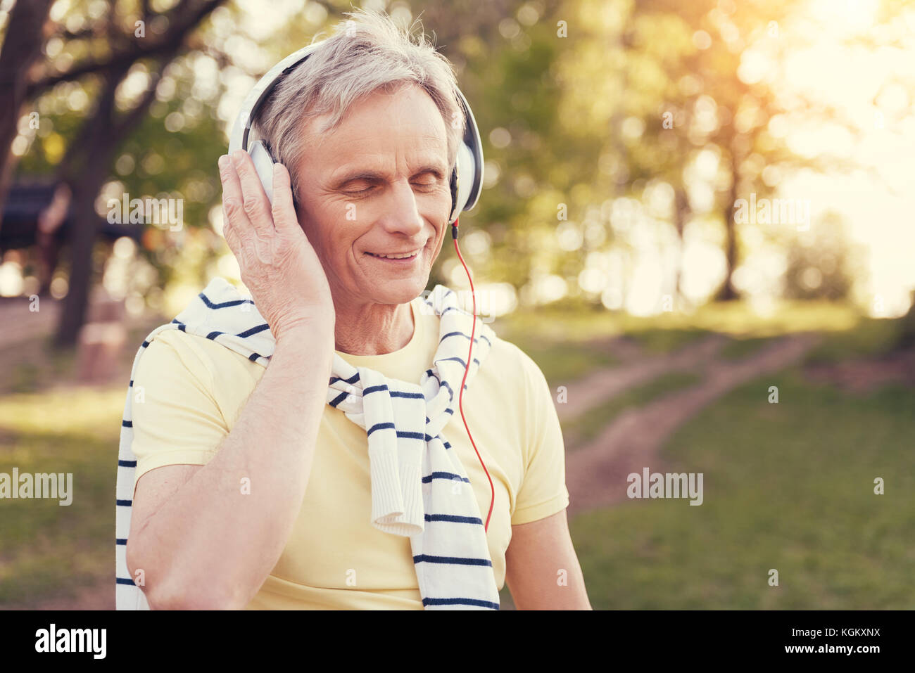 Lieto uomo più anziano di indossare le cuffie Foto Stock