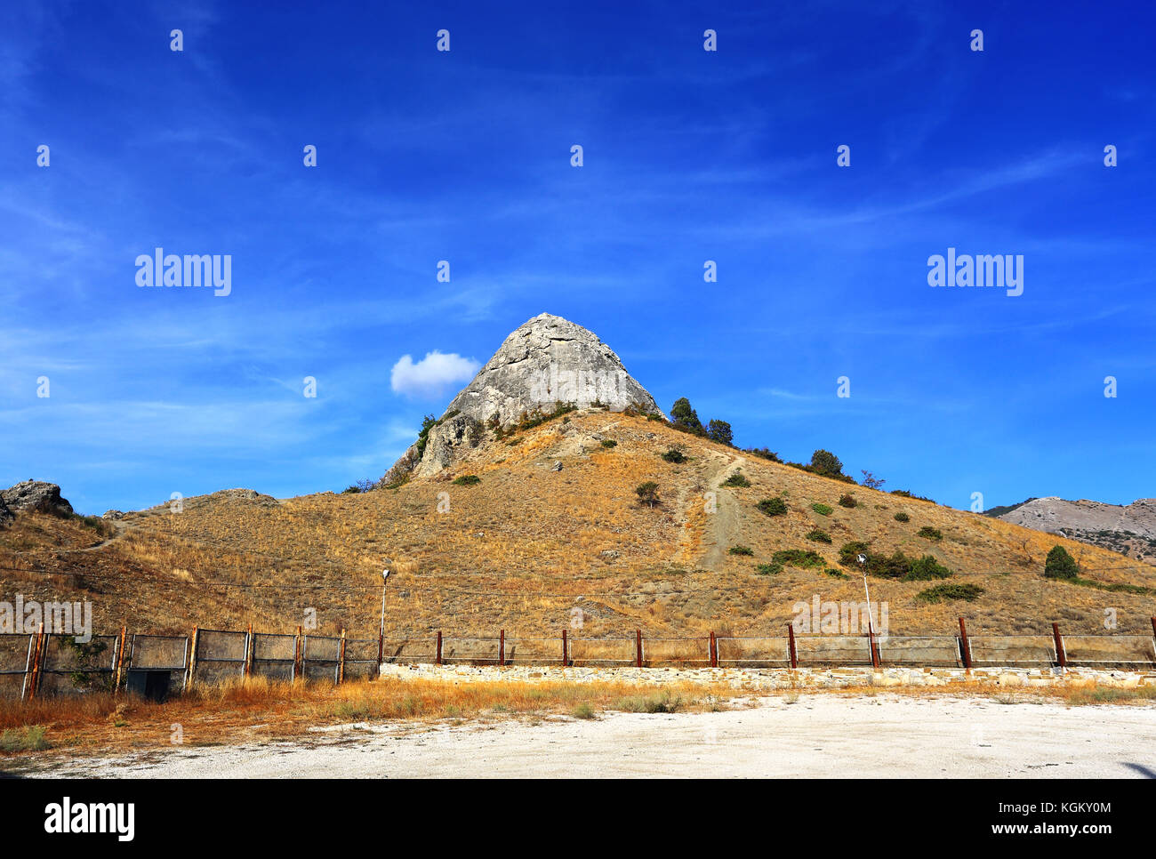 Il picco roccia sulla cima di una collina ricoperta con boccole Foto Stock