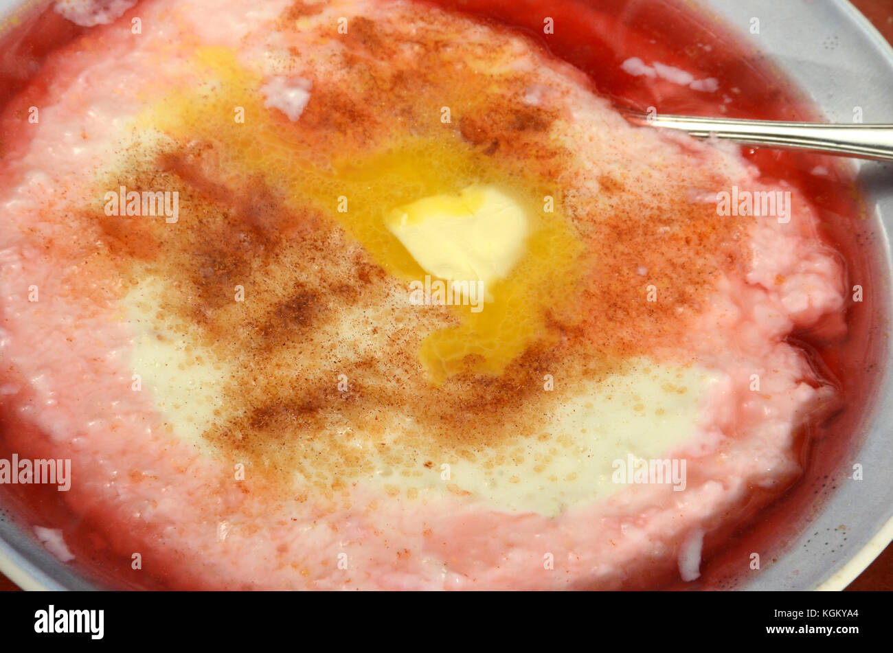 Budino di riso con burro, salsa rossa e cannella. Foto Stock