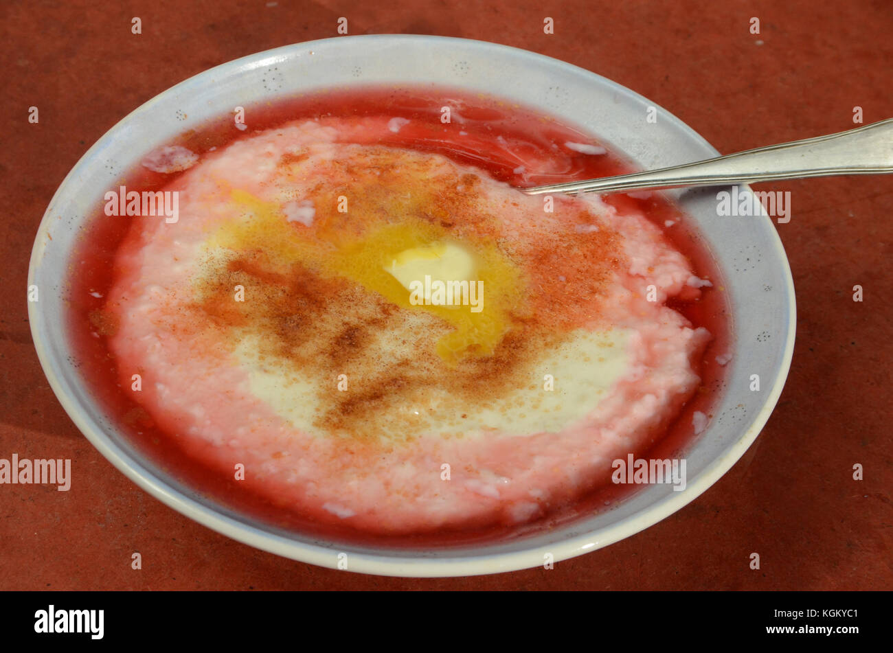 Budino di riso con burro, salsa rossa e cannella. Foto Stock