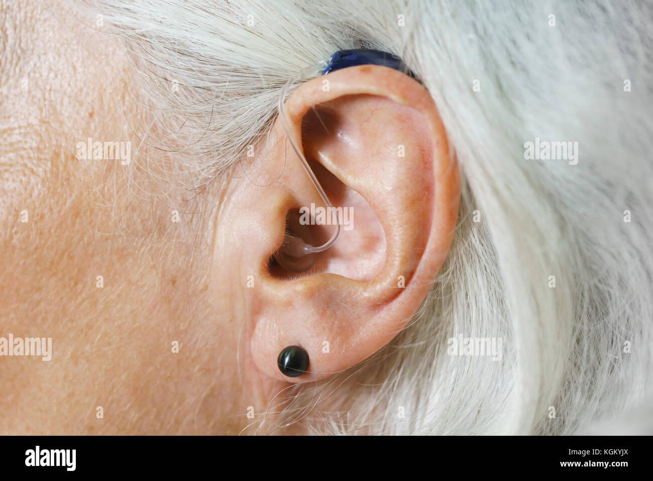 Close-up di donna con i capelli grigi che indossa Hearing Aid Foto Stock