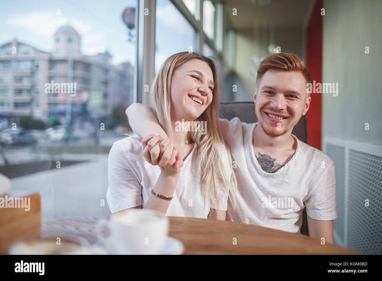 Ritratto di uomo sorridente seduto con la fidanzata al ristorante Foto Stock