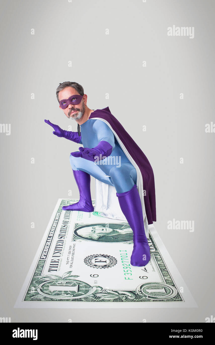 Il supereroe che la piegatura con le braccia aperte e gambe divaricate su American artificiale di un dollaro Foto Stock
