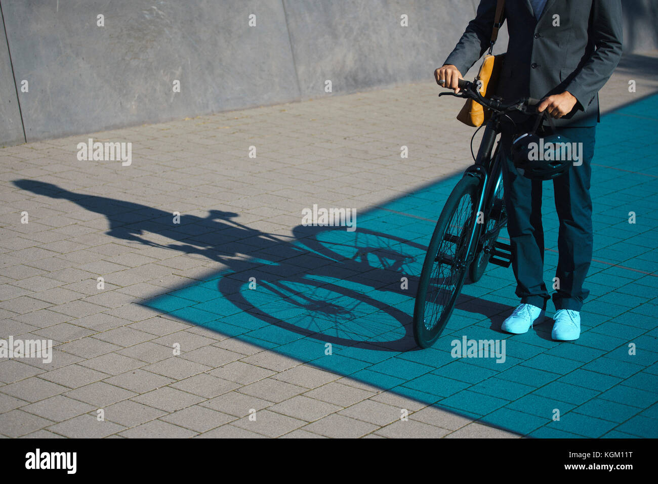 Sezione bassa di imprenditore in piedi con la bicicletta su strada Foto Stock