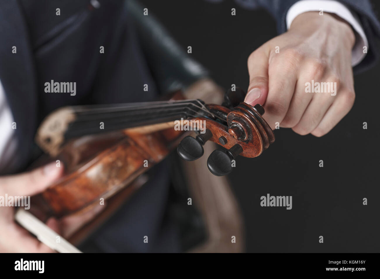 Immagine ritagliata del musicista tuning Violin strings Foto Stock