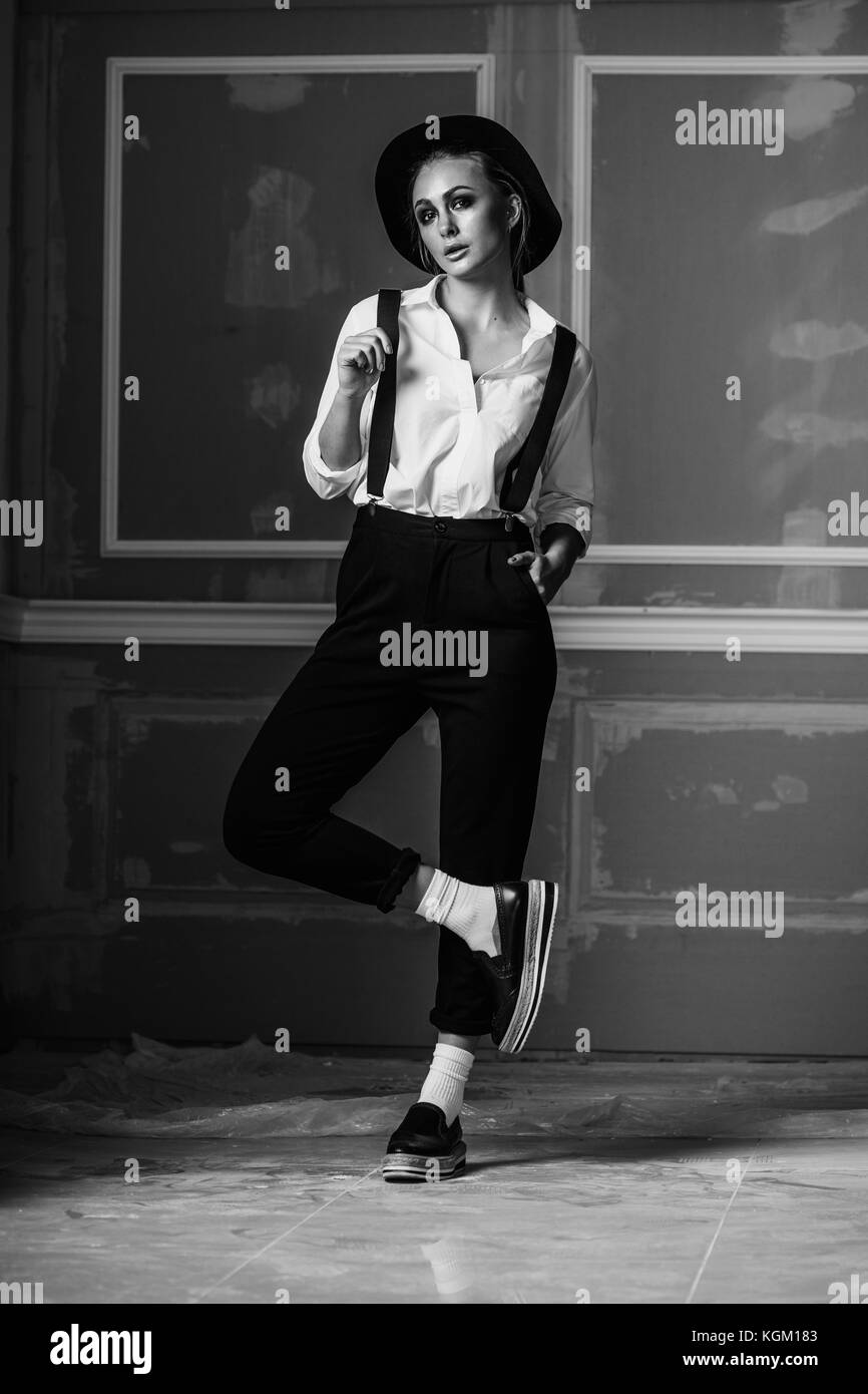 Per tutta la lunghezza della giovane donna di indossare calze autoreggenti in piedi contro la parete Foto Stock