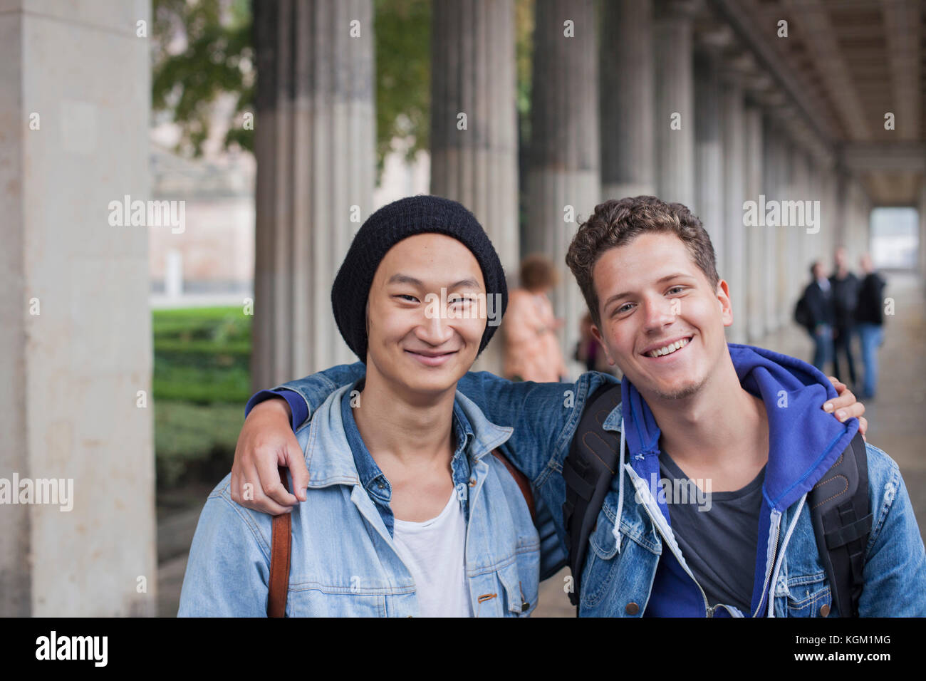 Ritratto di giovane sorridente amici maschi in piedi con le braccia intorno a Berlino, Germania Foto Stock
