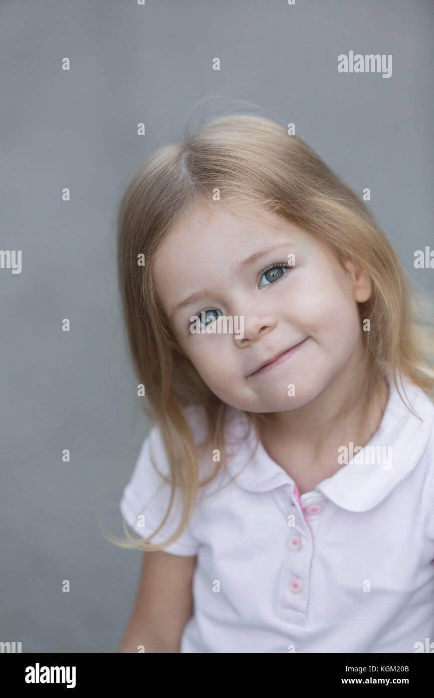 Ritratto di ragazza carina contro uno sfondo grigio Foto Stock