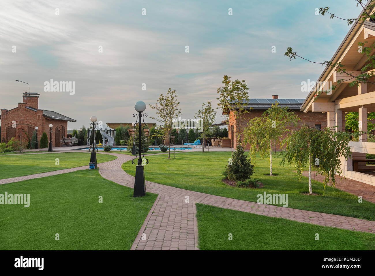 Luci elettriche da un sentiero sul prato in back yard contro sky Foto Stock