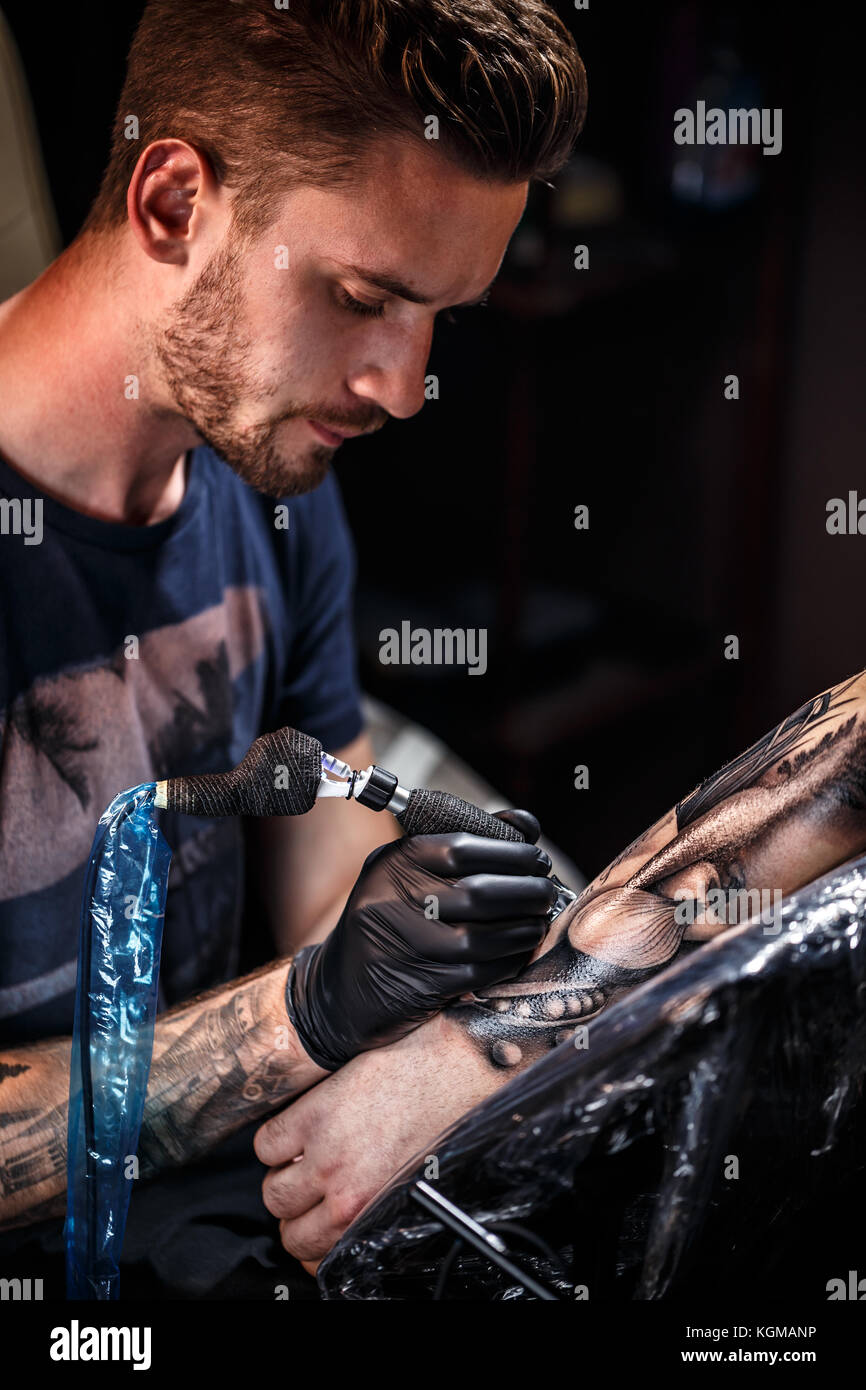 Tattoo Artist tattoo si applica al braccio Foto Stock