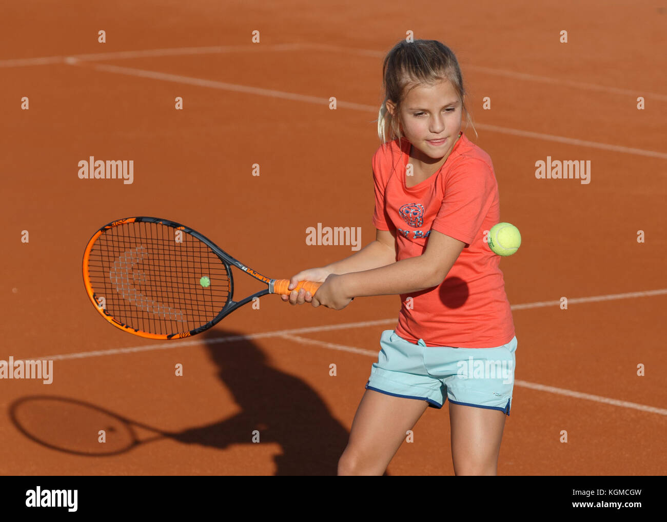 Ragazza giovane (8)0 giocare a tennis Foto Stock