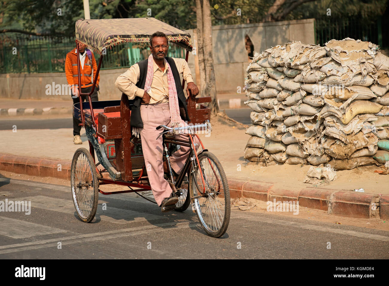 Delhi, India - 20 novembre 2015: indiano uomo seduto su un risciò ciclo di attesa per le persone per il trasporto Foto Stock