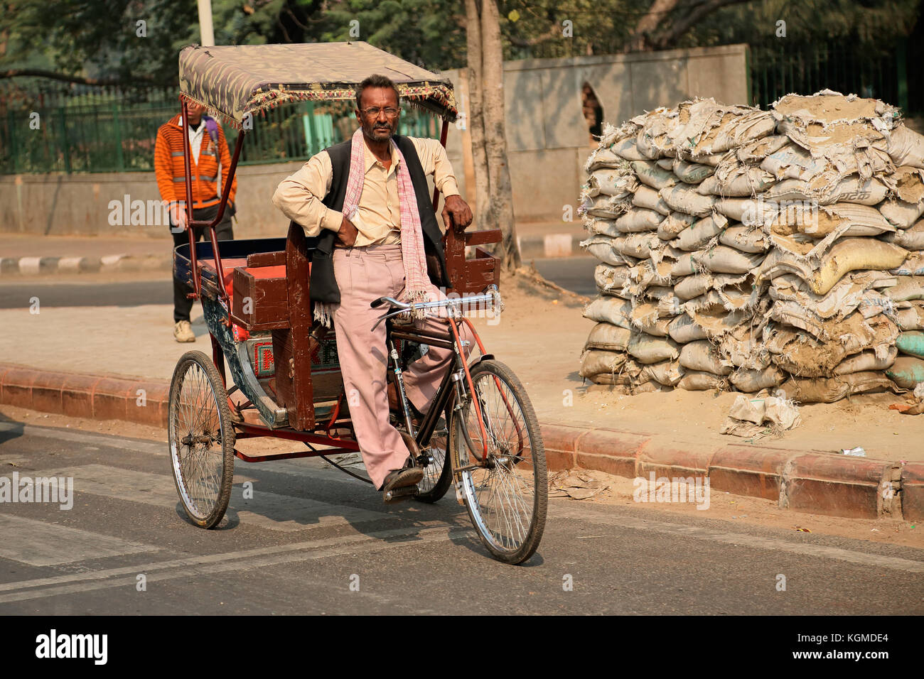 Delhi, India - 20 novembre 2015: Uomo indiano seduto su un risciò in bicicletta in attesa che le persone trasportino Foto Stock