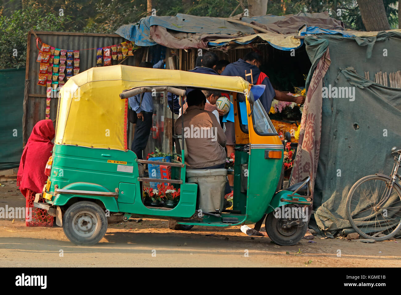 Delhi, India - 24 novembre 2015: venditori ambulanti e un tuk-tuk veicolo che è tipico delle strade affollate di vecchia Delhi Foto Stock