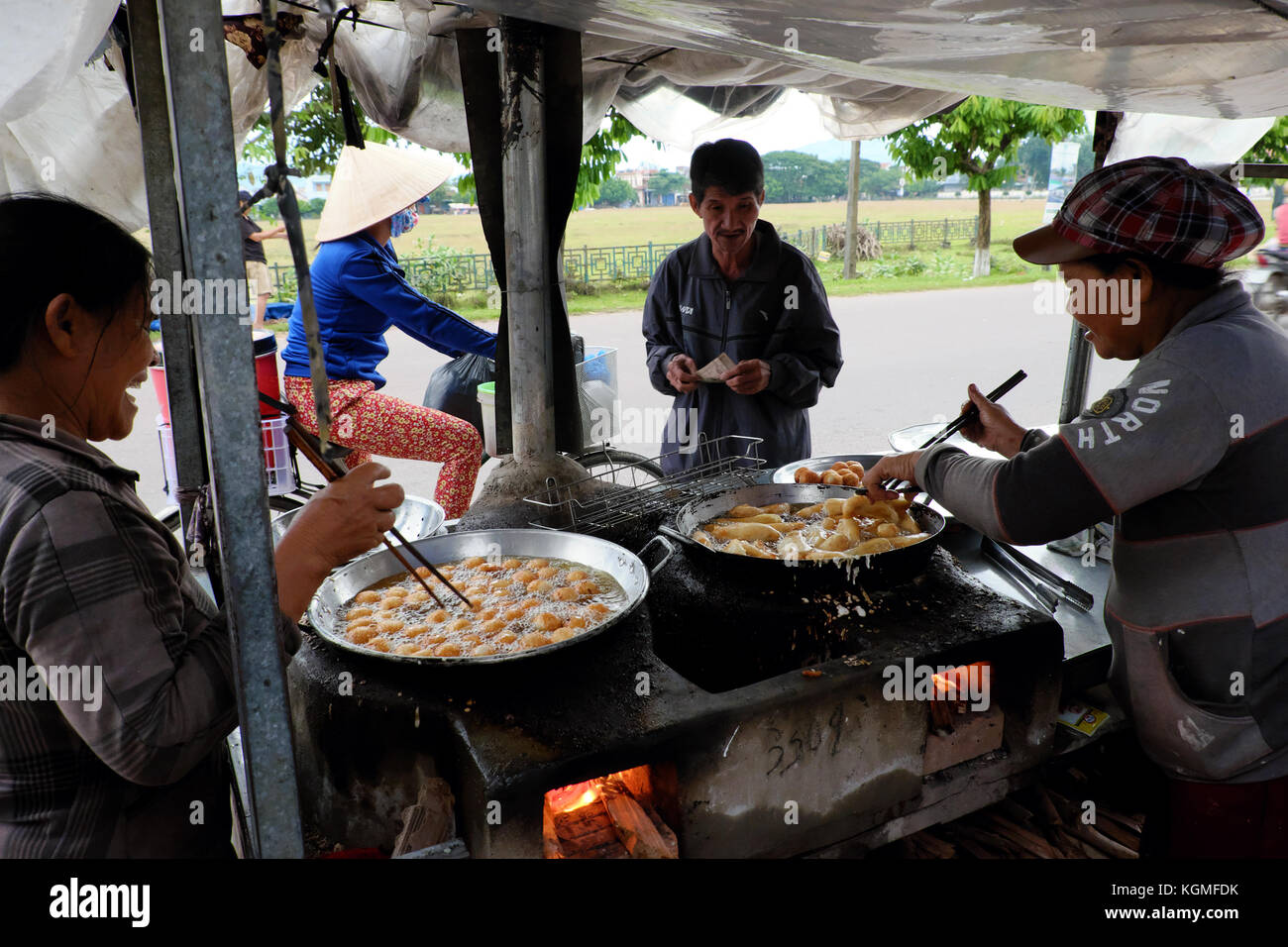 Binh Dinh, Viet Nam, vietnamita donna street food vendor guadagnare soldi da snack alimentare sulla strada, femmina asiatica Frittura di banane fritte su hawk, Vietnam Foto Stock