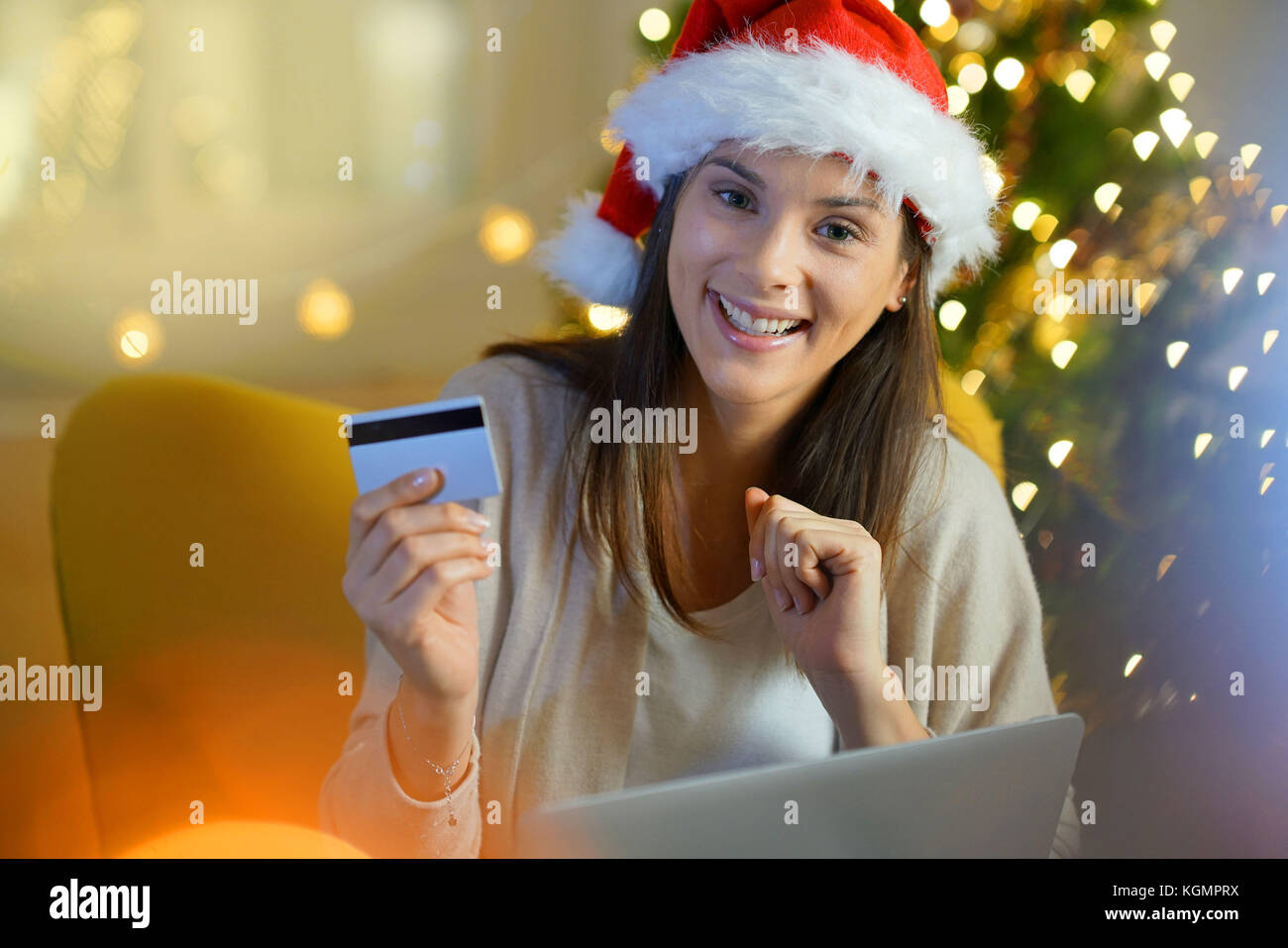 Donna con cappello da Babbo Natale acquisto regalo di natale su internet Foto Stock