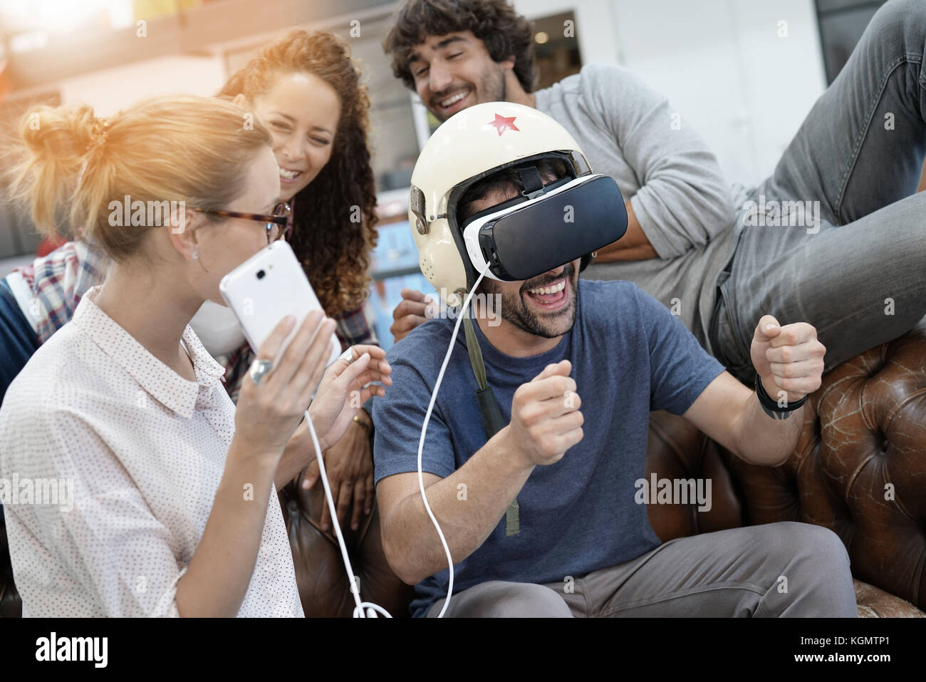 Gruppo di amici a giocare insieme con la realtà virtuale auricolare Foto Stock