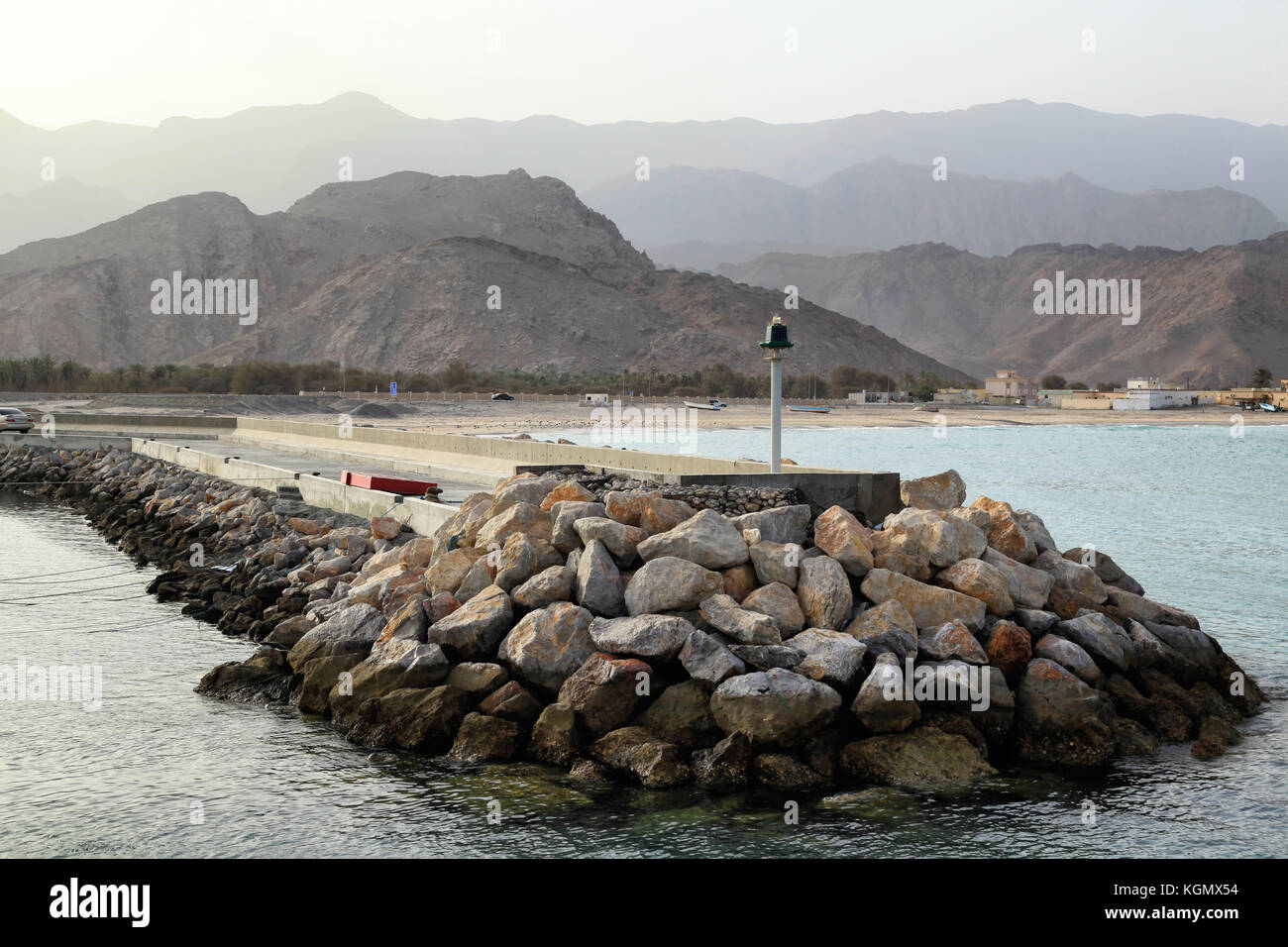 Vista su un piccolo porto in oman durante il tramonto, al montagne Hajar in background Foto Stock