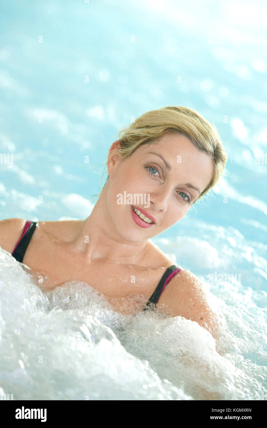 Donna di mezza età godendo il bagno termale nel centro di talassoterapia Foto Stock