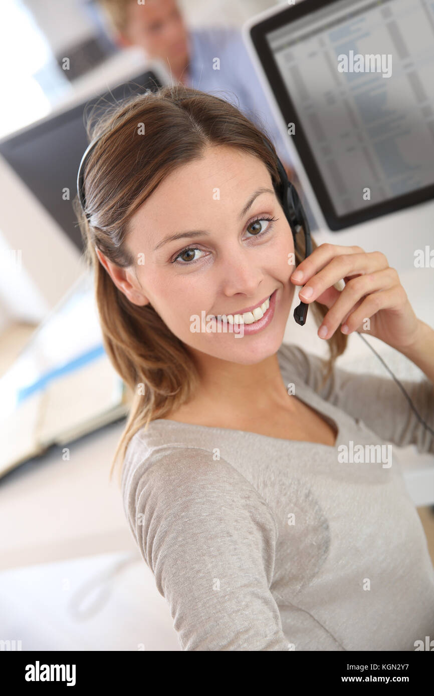 Bella teleoperator sorridente con cuffia Foto Stock