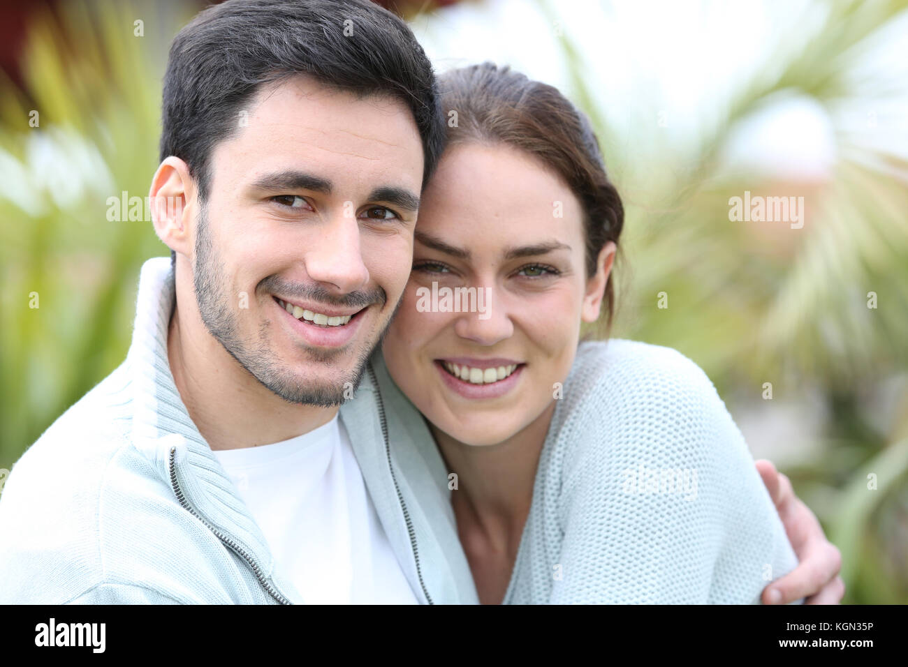 Giovane che abbraccia ogni altro di fronte a casa Foto Stock