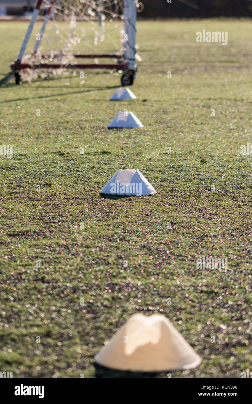 Allenamento di calcio coni segna il passo con un obiettivo di post in background. Foto Stock