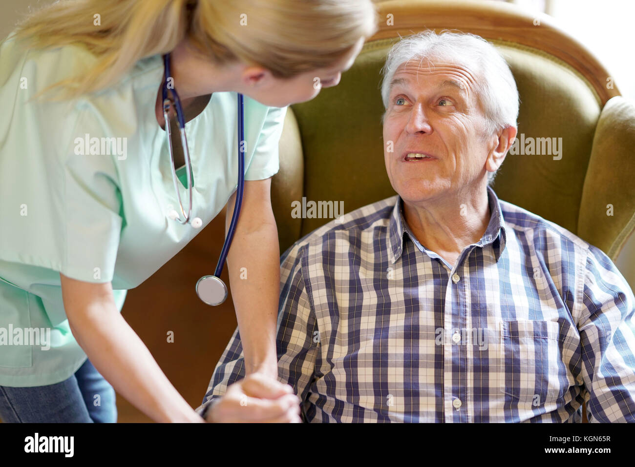 Ritratto di felice uomo anziano guardando un infermiere di prendersi cura di lui Foto Stock