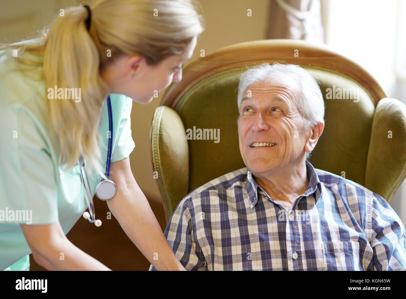 Ritratto di felice uomo anziano guardando un infermiere di prendersi cura di lui Foto Stock