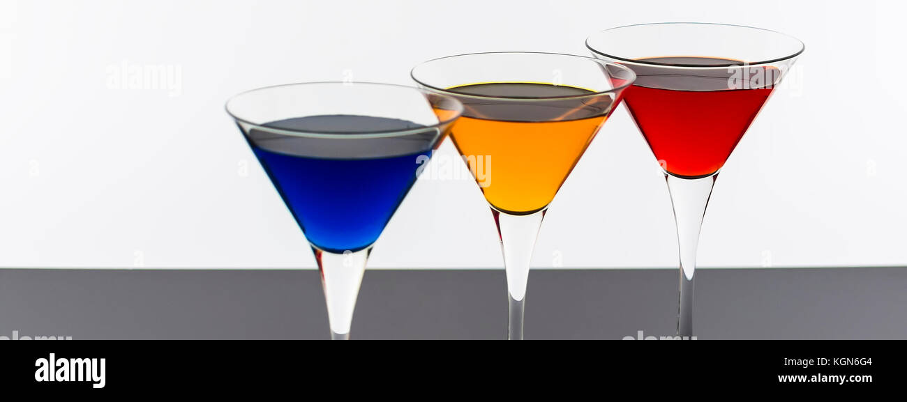 Cocktail colorati in bicchieri da martini sfondo. bar spot concetto. Foto Stock