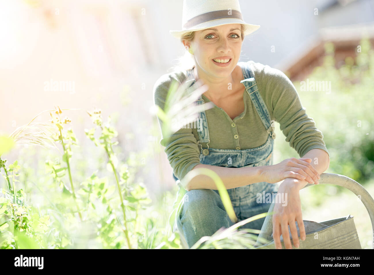 Donna bionda con hat giardinaggio sulla giornata di sole Foto Stock