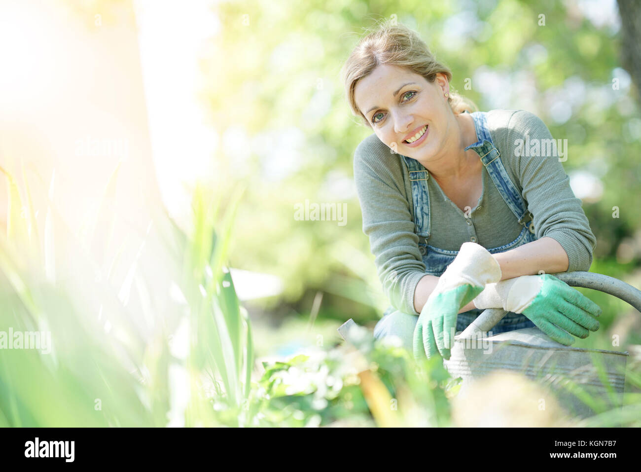 Sorridente donna bionda giardinaggio Foto Stock