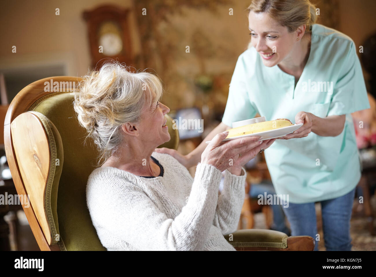 Infermiere portando la colazione per senior paziente femmina Foto Stock