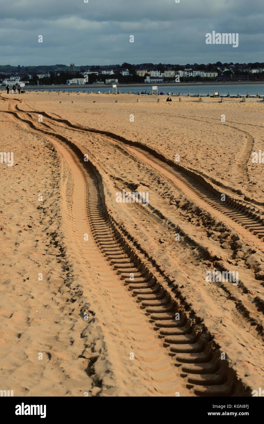 Caterpillar Tracks nella sabbia, creato da macchine per movimento terra accesso alla spiaggia per la manutenzione. Guardando verso Exmouth. Foto Stock