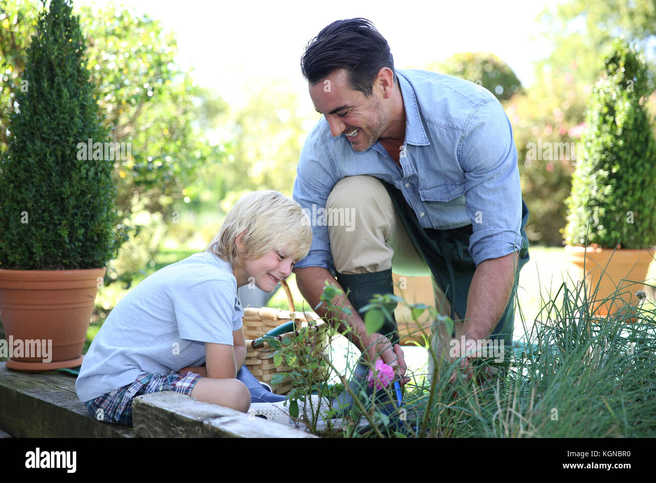 Little Boy divertendosi con daddy giardinaggio Foto Stock