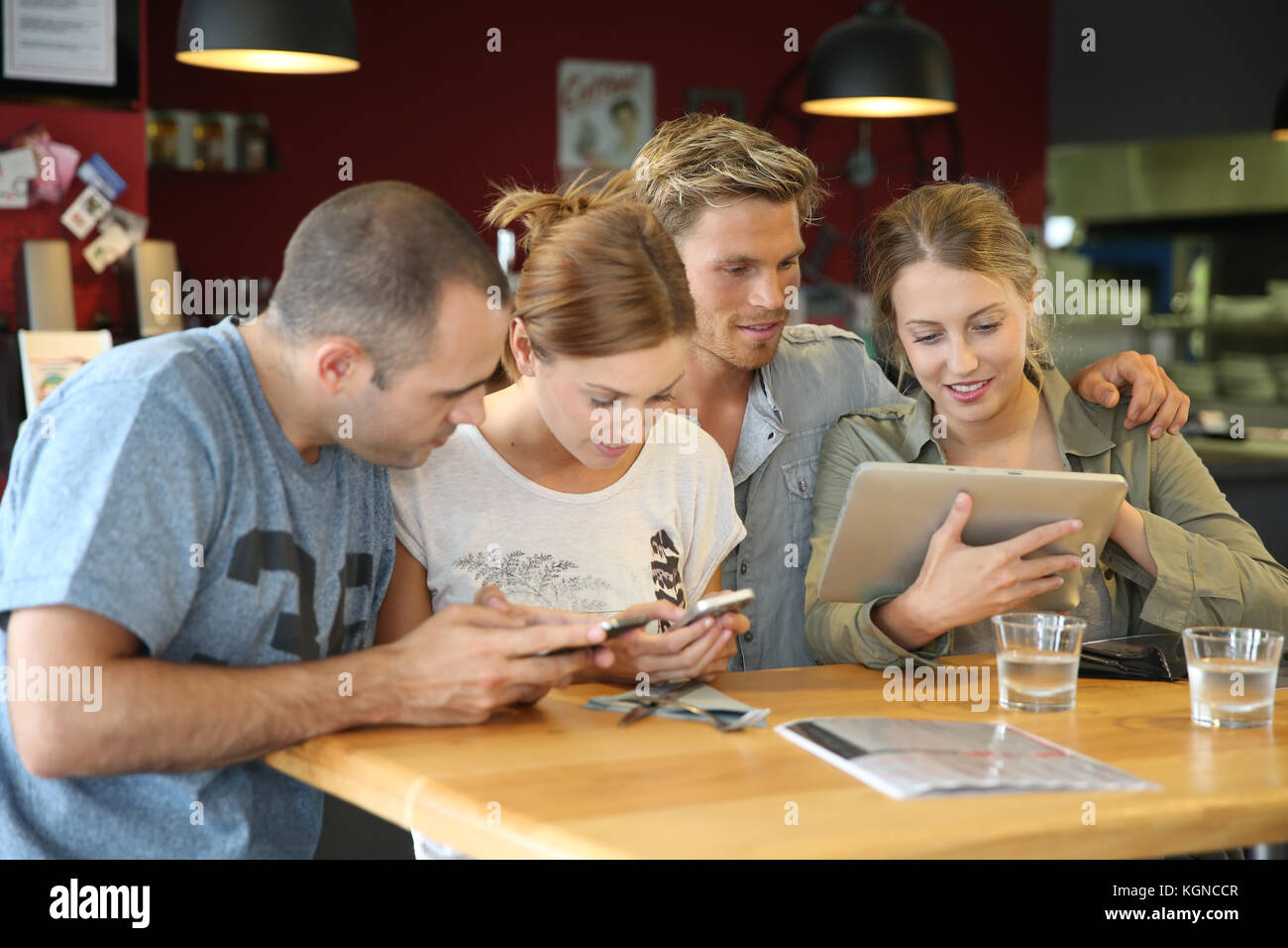 Gli studenti nei campus universitari lounge websurfing su tablet Foto Stock