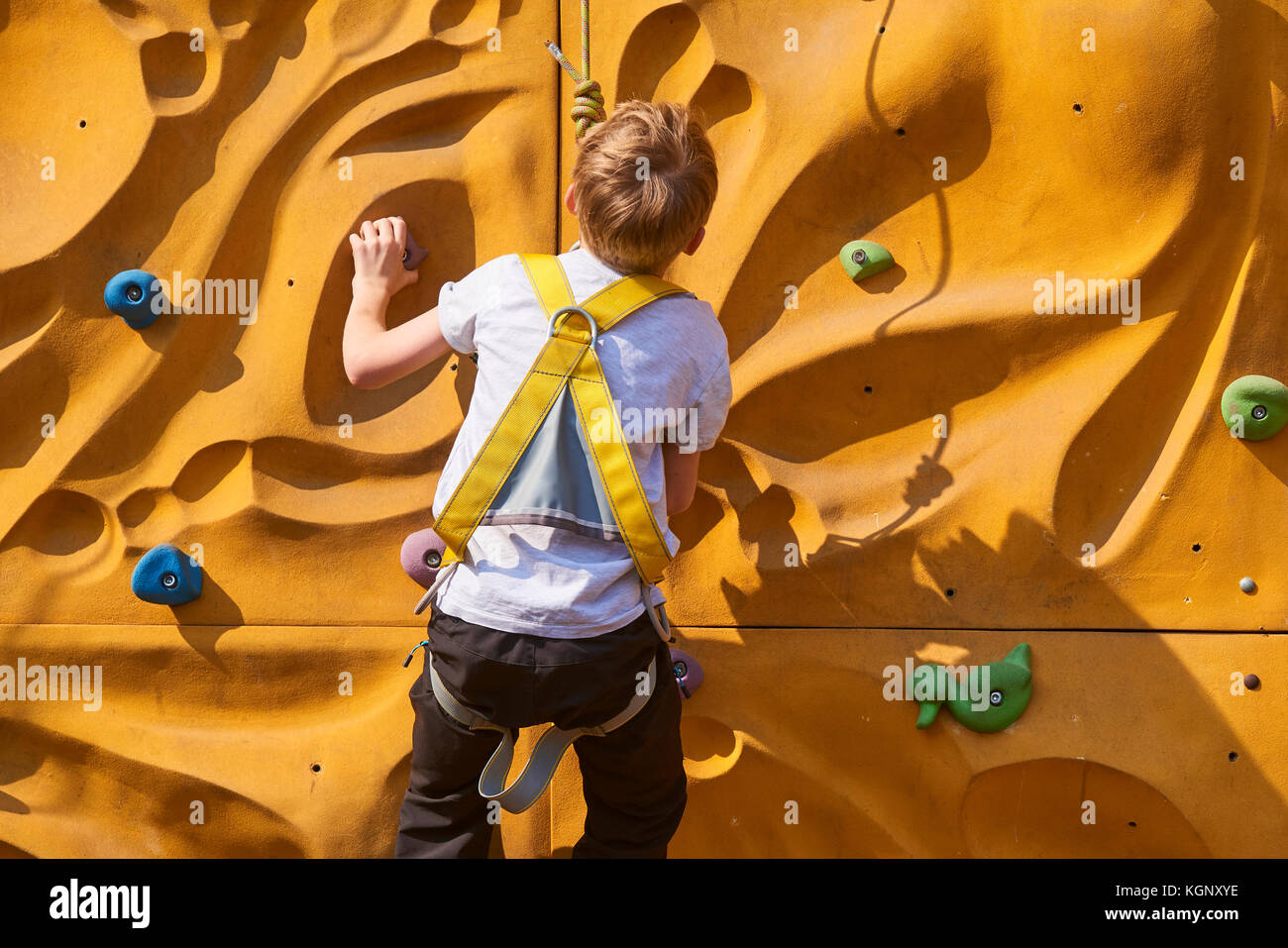 Bambino scalare una parete di roccia outdoor - bouldering Foto Stock