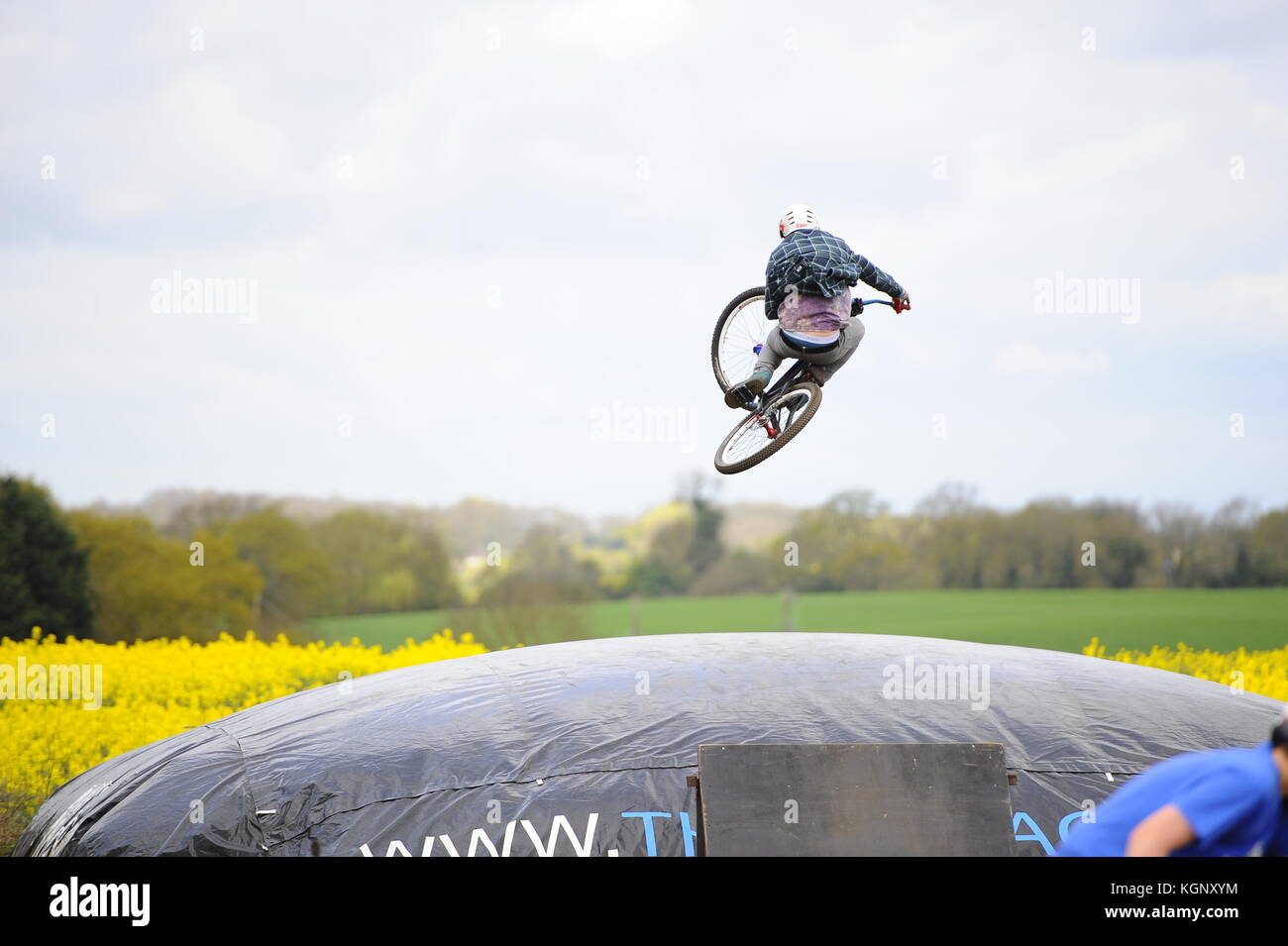 Mountain bike a chicksands, bedfordshire. piloti salta fuori da un grande togliere la rampa verso un enorme airbag. cercando & perfezionando nuovi trucchi. Foto Stock