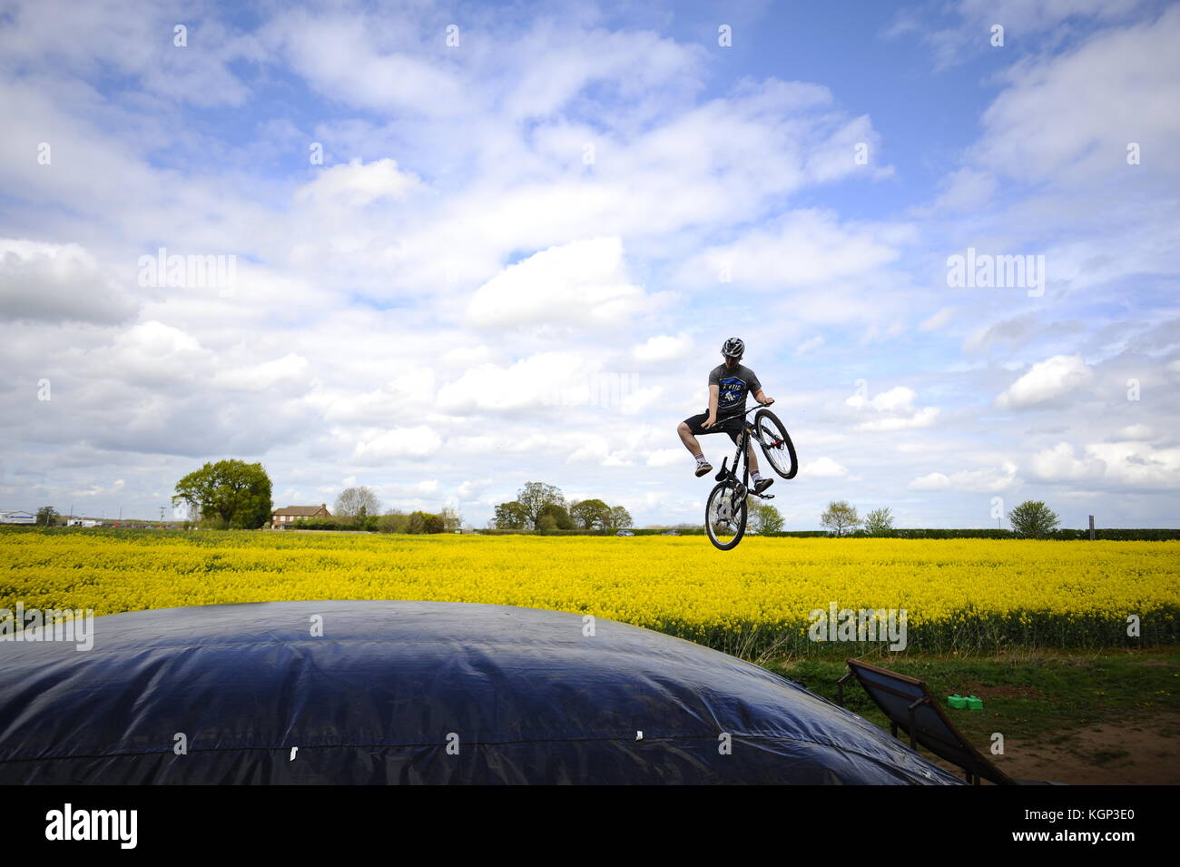 Mountain bike a chicksands, bedfordshire. piloti salta fuori da un grande togliere la rampa verso un enorme airbag. cercando & perfezionando nuovi trucchi. Foto Stock