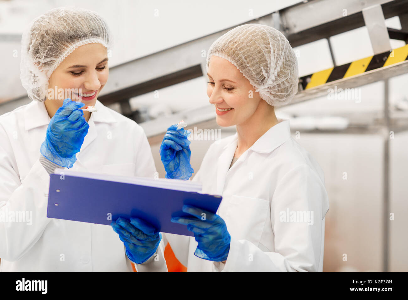 Donne tecnologi degustazione di gelati in fabbrica Foto Stock