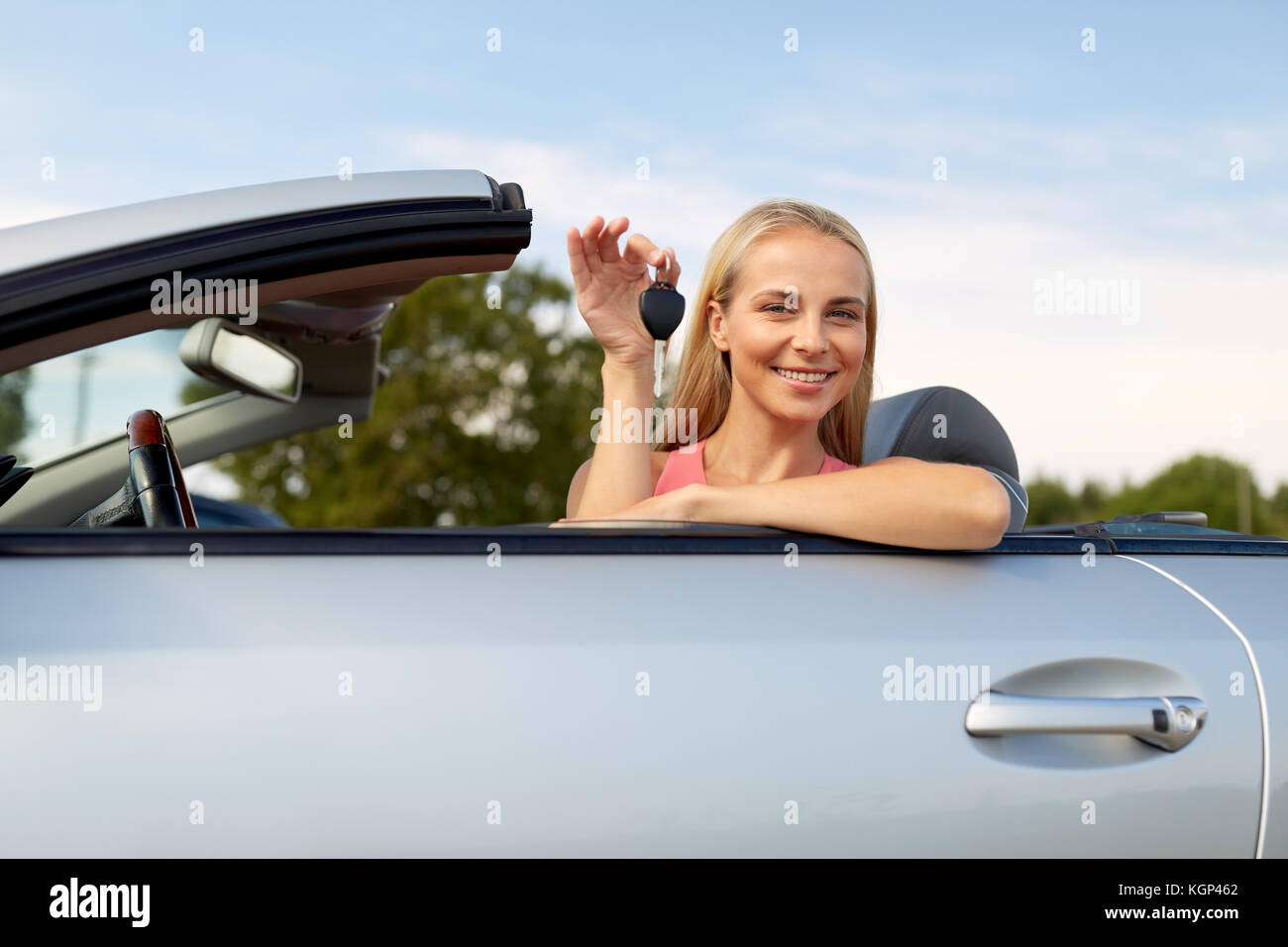 Felice giovane donna con autovettura convertibile key Foto Stock