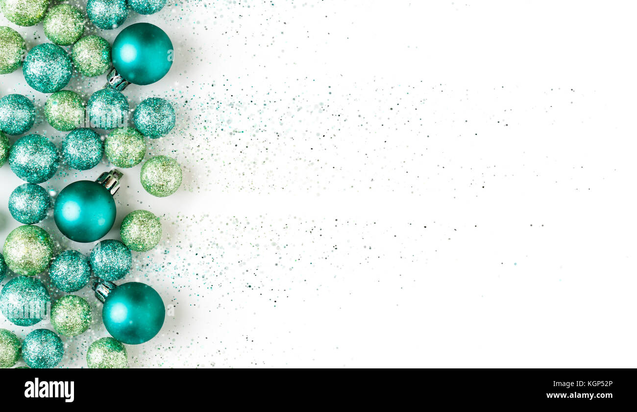 Bella, luminosa, moderna, il blu e il verde per le vacanze di Natale ornamenti decorazioni con scintillanti glitter su sfondo bianco. Bordo orizzontale. Foto Stock
